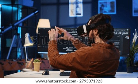 Remote software developer using VR goggles in personal office at home to do javascript programming for online learning.