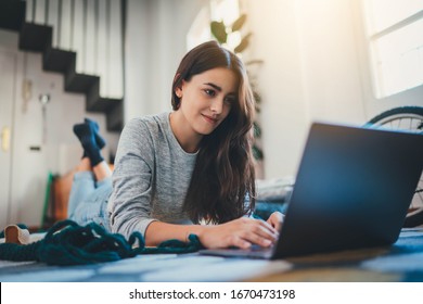 Remote Work, Attractive young woman translator working from home  remotely lying in comfortable living room using modern laptop computer, Young girl having video call via laptop, Home Office Concept