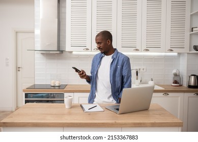 Remote Work. Handsome Black Freelancer Guy Looking At The Screen Of His Phone At Home. Working Online From Home.