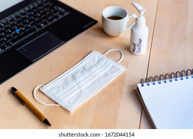 remote work kit on wooden office desk with hand sanitizer and face mask, a solution against the spread of corona virus for quarantined employees - Powered by Shutterstock