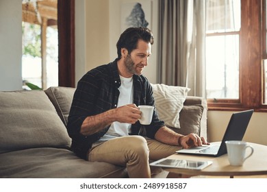 Remote work, laptop and man on sofa with drink, blog and company review at home. Male person, small business and technology in living room for contact, ecommerce and interior design on internet