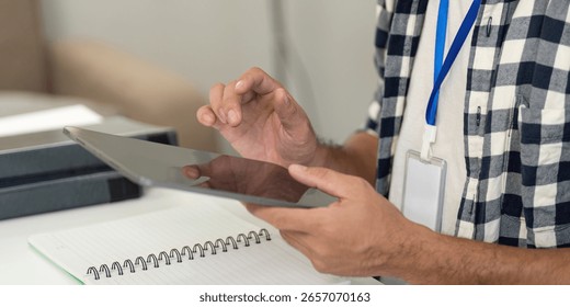 Remote Work. Professional man using tablet for digital tasks in a modern office.
