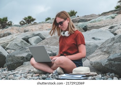 Remote work.Girl freelancer works remotely on the seashore.workation, remote work,WFVH,Van Life vibes work from vacation home,work travel,remotely work.Travelling - Shutterstock ID 2172912069