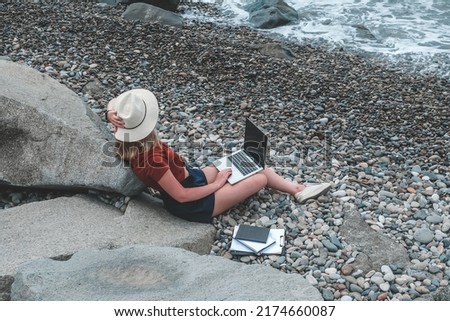 Remote work.Girl freelancer works remotely on the seashore.workation, remote work,WFVH,Van Life vibes work from vacation home,work travel,remotely work.Travelling