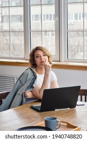 Remote Working From Home. Girl Freelancer Workplace In Kitchen With Laptop, Mug Of Tea Or Coffee. Concept Distance Learning, Self Isolation, Female Small Business, Shopping Online. Lifestyle Moment.