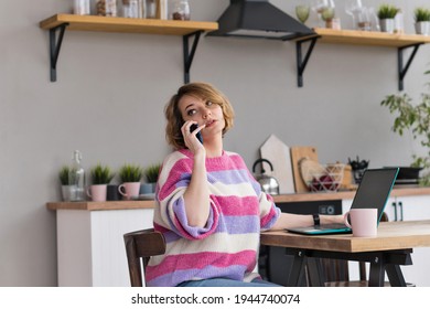 Remote Working From Home. Girl Freelancer Workplace In Kitchen With Laptop, Mug Of Tea Or Coffee. Concept Distance Learning, Self Isolation, Female Small Business, Shopping Online. Lifestyle Moment.