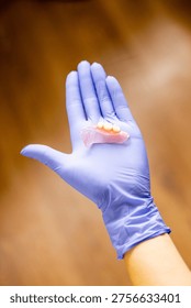 Removable partial denture prosthesis displayed by dentist illustrating orthopedic dental treatment for tooth loss replacement and prosthodontic restoration in clinical dentistry