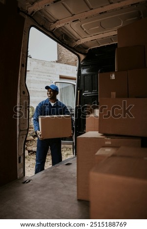 Removal service worker unloading box from the van