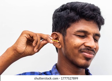 Remove Ear Wax Safely - Man Cleaning Ear With Cotton Swabs Closeup Shot. Cleaning Ear With Cotton Bud Dirty Ear. Removing Earwax Using Cotton Bud On White With Copy Space Text - Concept Healthy Care