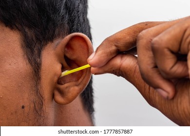 Remove Ear Wax Safely - Man Cleaning Ear With Cotton Swabs Closeup Shot. Cleaning Ear With Cotton Bud Dirty Ear. 