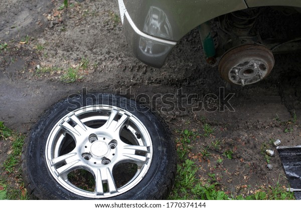 Removed car wheel. The\
drive from the wheels of the car. The concept of replacing the\
wheel on the car.