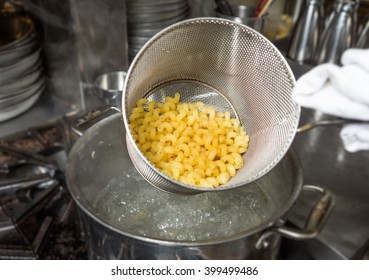 Removing Cooked Macaroni Pasta Out Of A Pan Of Boiling Water.