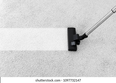Removing dirt from soft carpet with vacuum cleaner indoors