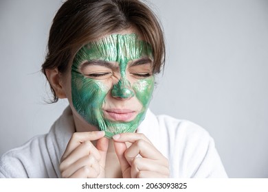 Removing A Green Cosmetic Mask From The Attractive Girl Face.