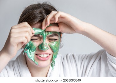 Removing A Green Cosmetic Mask From The Attractive Girl Face.