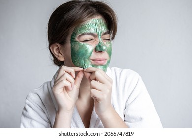 Removing A Green Cosmetic Mask From The Attractive Girl Face.