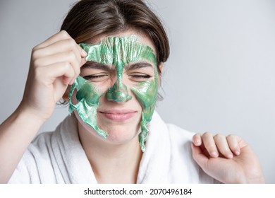 Removing A Green Cosmetic Mask From The Attractive Girl Face.