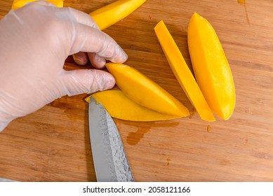 Removing The Mango Skin With A Standard Kitchen Knife While Wearing Plastic Gloves. Ingredient For California Maki.