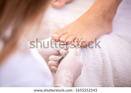 Removing of nail edges with nail clippers in foot spa, pedicure