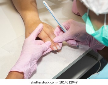 Removing the nail plate with a milling machine. Manicure process in beauty salon, cleaning of nails by a milling cutter. Manicurist filing client's nails at table, close up. - Shutterstock ID 1814812949