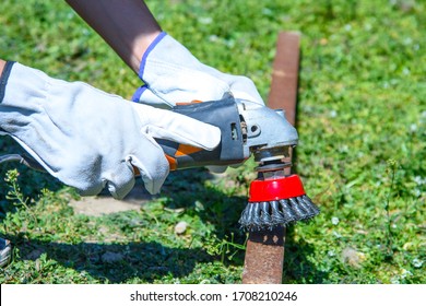 Removing Rust And Paint From An Old Metal Pipe With A Wire Brush, Closeup