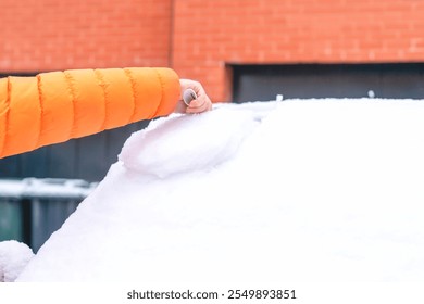 Removing snow from a car windshield during a winter morning in a suburban area - Powered by Shutterstock