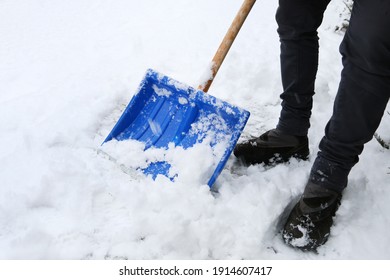 Removing snow from the sidewalk after snowstorm.