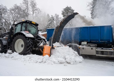 Removing snowdrift from city streets with snow blower.