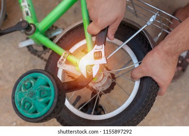 Removing The Training Wheels. Father Repairing His Kids Bicycle.