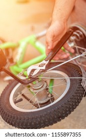 Removing The Training Wheels. Father Repairing His Kids Bicycle.