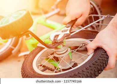 Removing The Training Wheels. Father Repairing His Kids Bicycle.