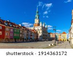 Renaissance building of historic Poznan Town Hall surrounded by colorful townhouses in Market Square in sunny day, Poland