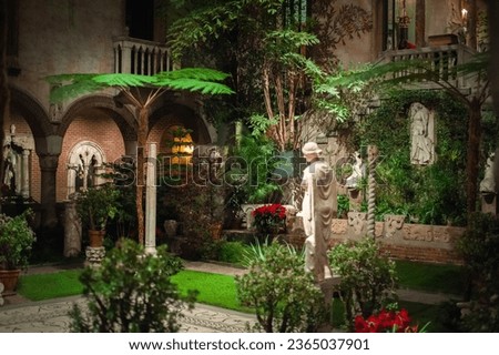 renaissance, byzantine and gothic style elements of arcade and a fountain decorating courtyard with tropical plants