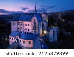 Renaissance castle Sternberk illuminated by lamps and evening lights in background. Pink and violet colors, Sternberk, Olomouc region, Moravia, Czech republic.