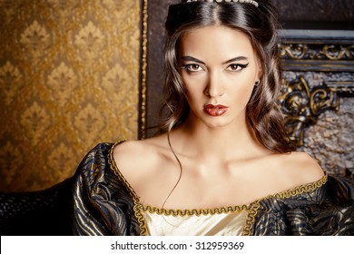 Renaissance Style -  Beautiful Young Woman In The Lush Expensive Dress In An Old Palace Interior. Vintage Style. Fashion.