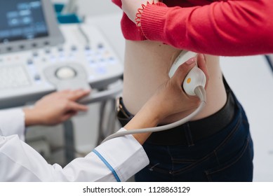 Renal Ultrasound Examination Of Kidneys. Hospital Doctor Examines A Young Woman With Ultrasound.