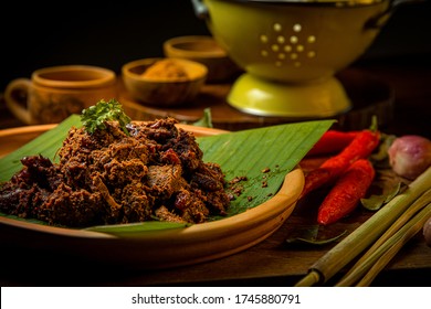 Rendang Daging Sapi or Beef stew traditional food from Padang, Indonesia. The dish is arranged among the spices and herbs used in the original recipe like chili, lemongrass onion