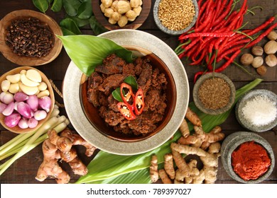Rendang Padang. Spicy beef stew from Padang, Indonesia. The dish is arranged among the spices and herbs used in the recipe.