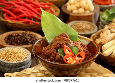 Rendang Padang. Spicy beef stew from Padang, Indonesia. The dish is arranged among the spices and herbs used in the recipe.