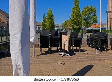 Renesse, Zeeland, Netherlands. May 5, 2020. Empty Closed Restaurant Terrace With Stacked Chairs On A Bright Sunny Day. Measure To Prevent COVID19 From Spreading. 