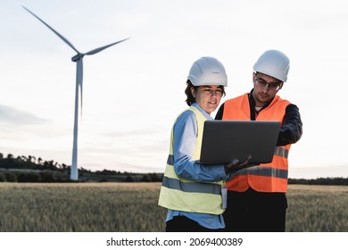 Renewable Clean Energy - Engineer People Working With Tablet At Wind Farm Station - Soft Focus On Woman Face