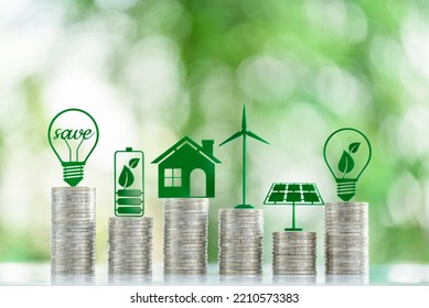 Renewable or clean energy generation prices and costs, financial concept : Green eco-friendly symbols atop coin stacks e.g. energy efficient light bulb, a battery, a solar cell panel, a wind turbine. - Powered by Shutterstock