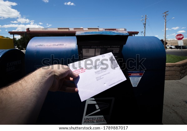 Reno, Nevada\
/ USA - June 9 2020: A voter casts a vote by mail ballot at the\
mailbox for the 2020 primary in\
Nevada.