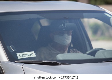 Reno, Nevada / USA - May 7 2020: An Uber driver wears a mask waiting to pick up a passenger as part of the companies new requirement for drivers and riders to wear a face covering. 