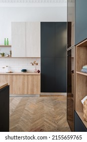 Renovierte Wohnung und komfortables Wohnkonzept. Vertikale Aufnahme neuer Möbel im KüchenInnenraum mit Holzschrank, Schrank und Parkettboden im Zimmer