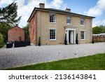 Renovated Grade II listed former village rectory with sash windows, porch, brick facade, side seating area and gravelled drive