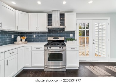 Renovated Kitchen With Stainless Steel Appliances, White Cabinets And Subway Glass Tile Backsplash In Single Family Residential Property.