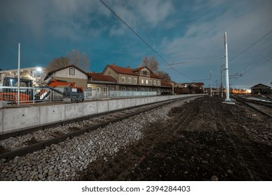 Renovating the historical train station of  Ljubljana Siska, making temporary platforms next to the railway track, putting down asphalt and rolling it with a roller. Night time photo, long exposure. - Powered by Shutterstock