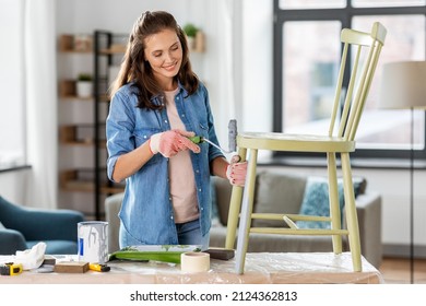 Renovation, Diy And Home Improvement Concept - Happy Smiling Woman In Gloves With Paint Roller Painting Old Wooden Chair In Grey Color