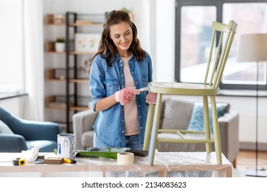 Renovation, Diy And Home Improvement Concept - Happy Smiling Woman In Gloves With Paint Brush Painting Old Wooden Chair In Grey Color